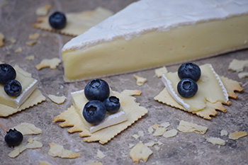 Crackers with brie cheese and blueberries