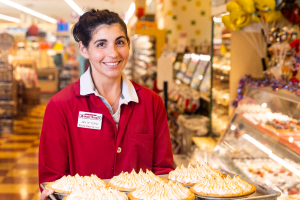 Bakery Associate holding a tray of pies.