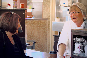 A Market's Cafe employee smiles with a customer