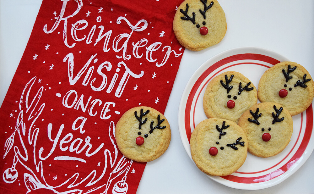 A plate of reindeer sugar cookies on a white background
