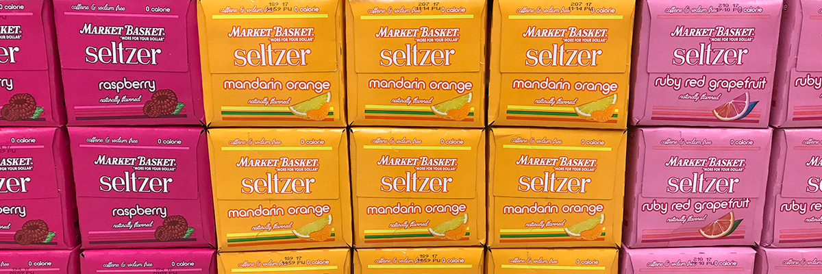 Assorted boxes of Market Basket seltzer cans on a shelf