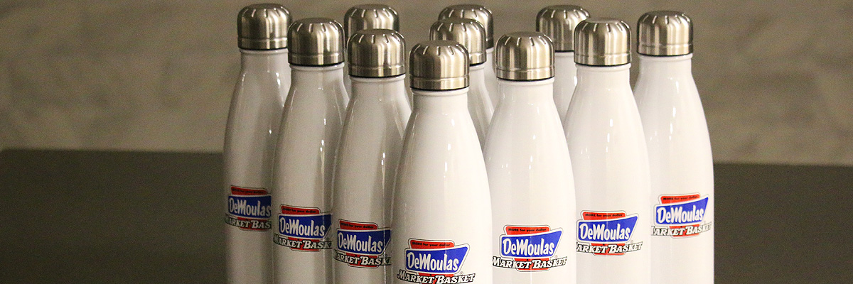 White DeMoulas Market Basket water bottles are aligned in a bowling pin pattern on a counter