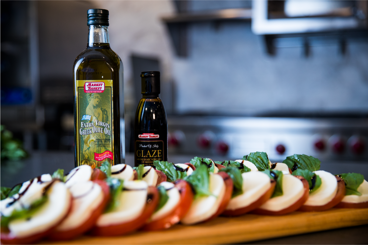 Caprese Salad Plated, in front of market basket olive oil and balsamic vinaigrette glaze
