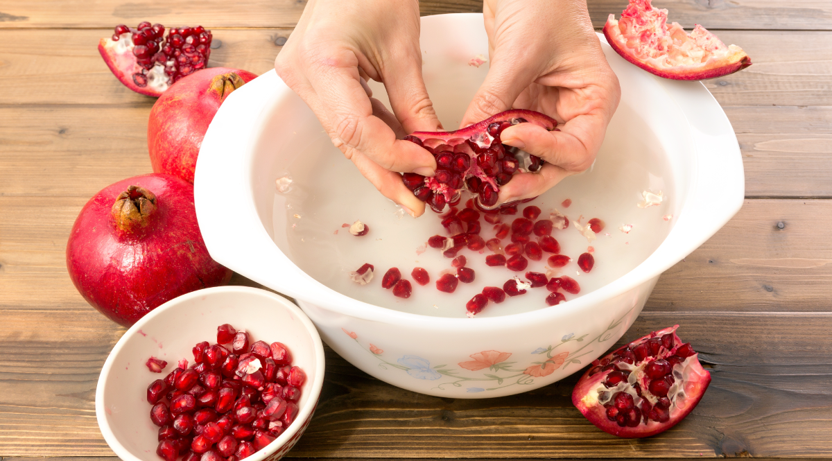 Deseeding the pomegranates in a bowl of water